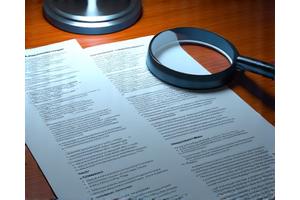 Documents and magnifying glass representing compliance assessment
